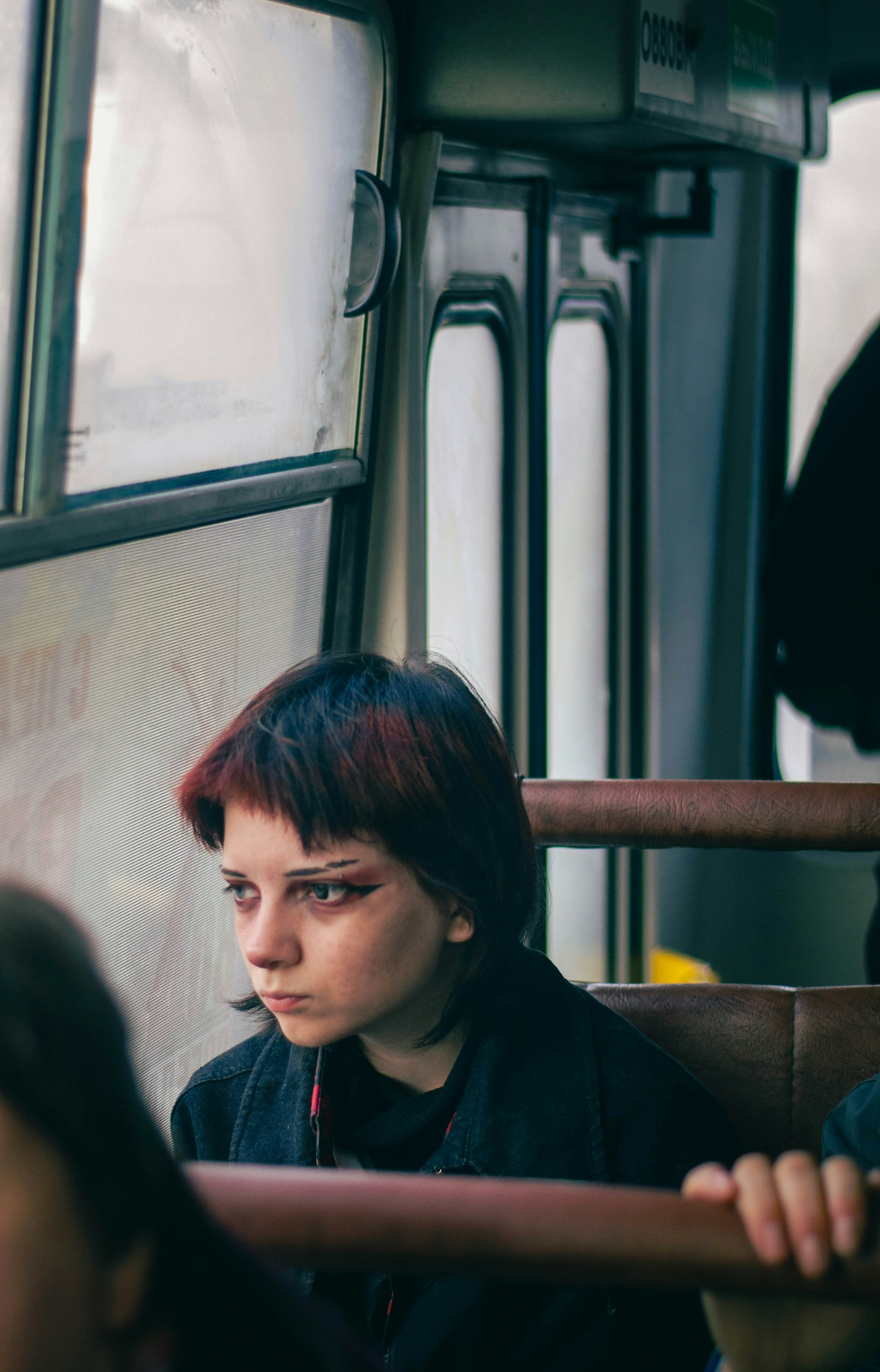 Підліток їде в автобусі й дивиться у вікно